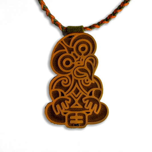 Brown-Orange  pendant with intricate design on a braided cord against a white background
