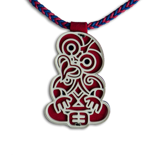Red and white pendant on a braided red and blue cord against a white background