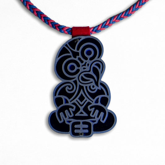 Dark Blue pendant with intricate design on a red and blue braided cord against a white background