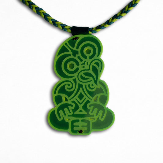 Green tribal-style pendant on a braided cord against a white background